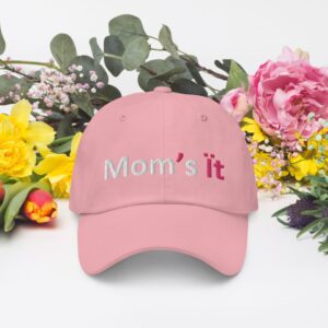 Pink cap with "Mom's it" amid flowers.