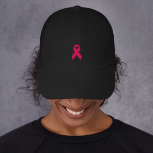 Person wearing black cap with pink ribbon.