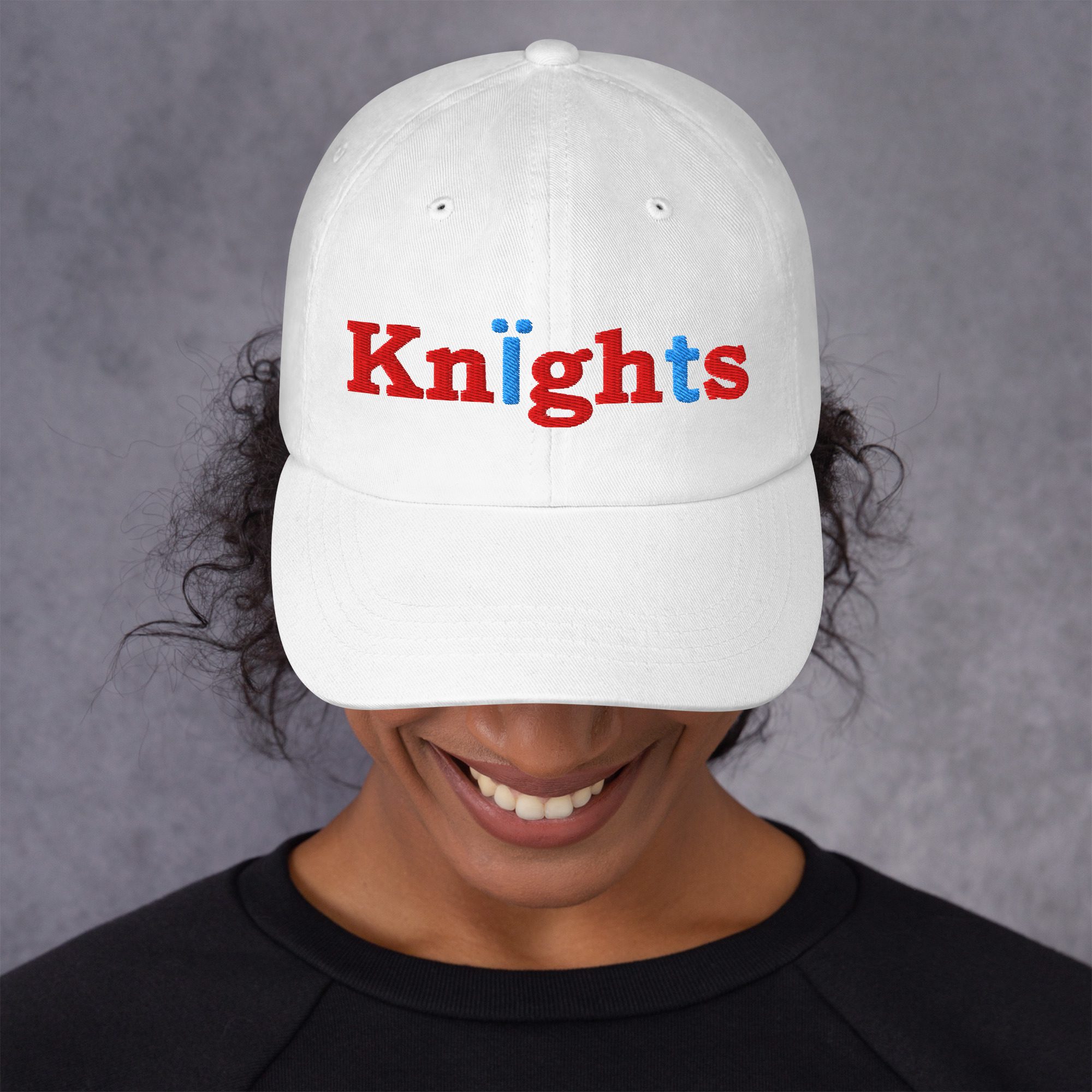 Person wearing white "Knights" embroidered cap.
