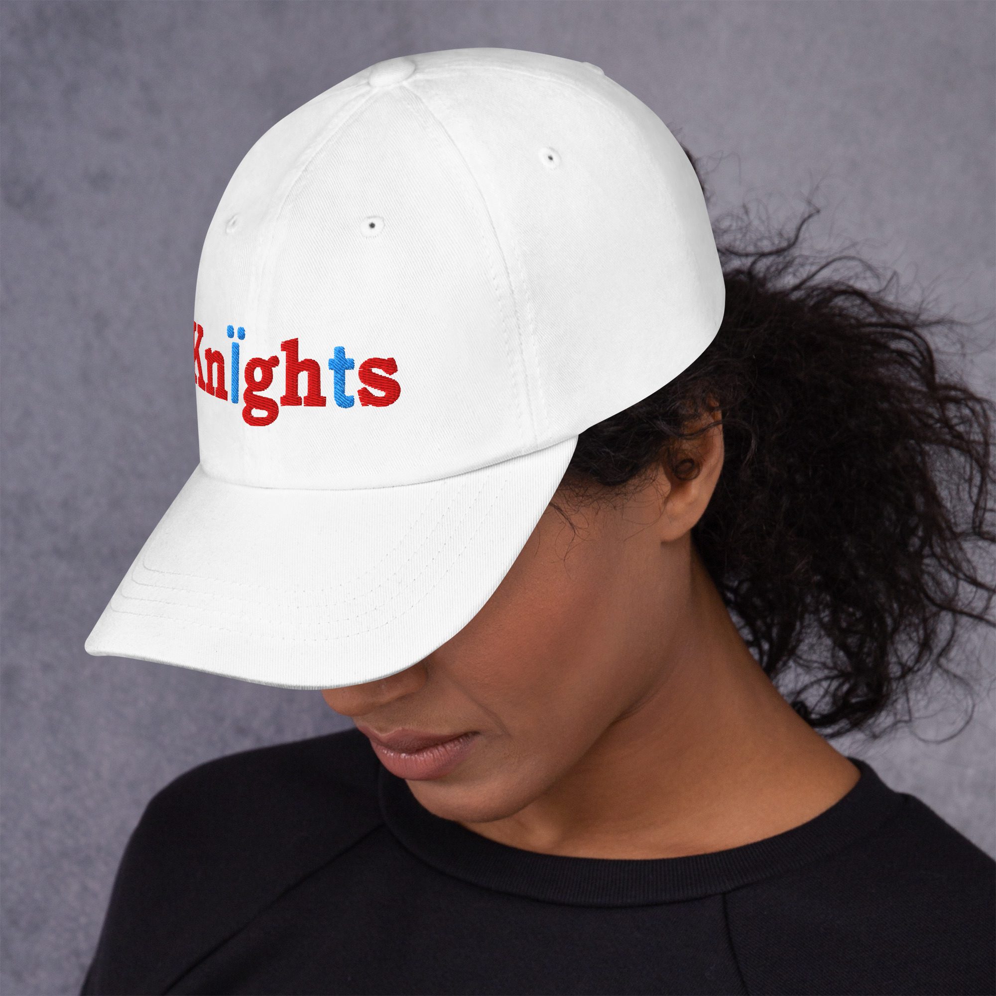 Person wearing white "Knights" embroidered cap.