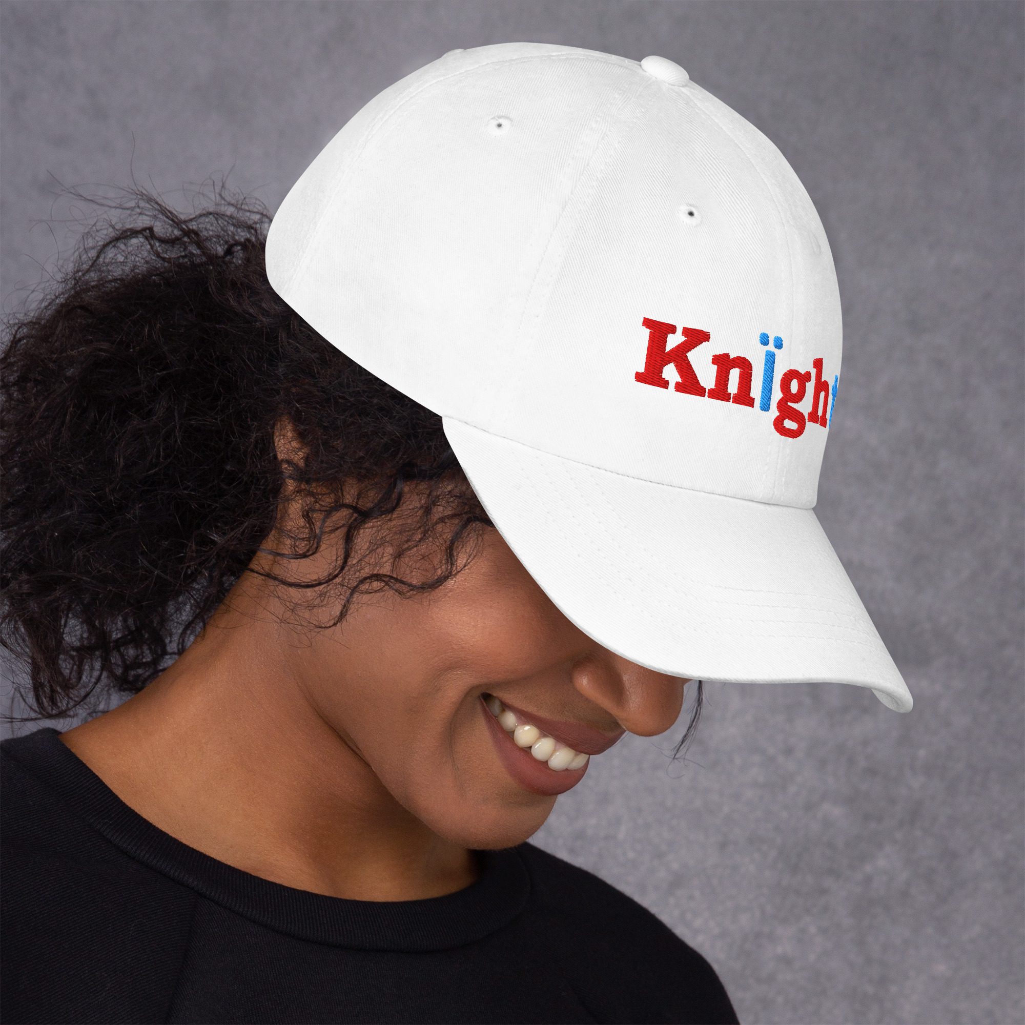 Woman wearing white cap with "Knight" text.